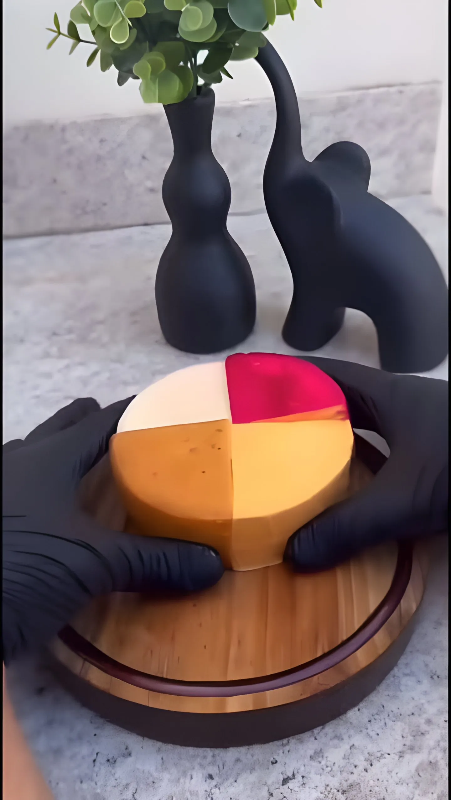 Queijo de quatro cores segurado com luvas pretas